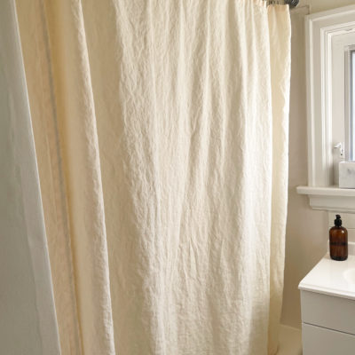 eco friendly shower curtain hanging on shower rail in bathroom