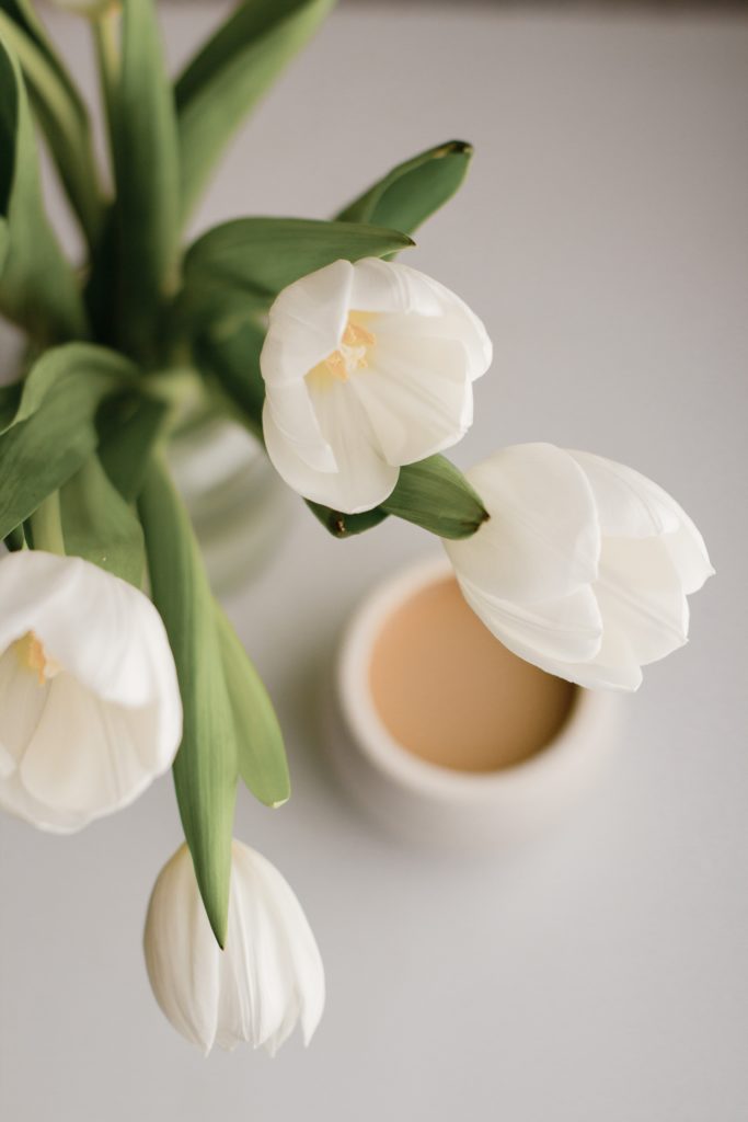 Image of eco-friendly white tulip flowers and mug of coffee